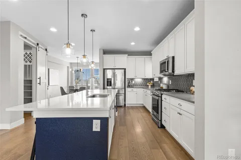 a large white kitchen with stainless steel appliances