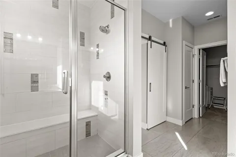 a bathroom with a shower and a glass door