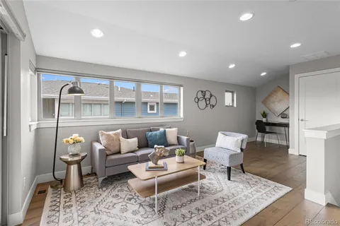 a living room with furniture and wooden floor