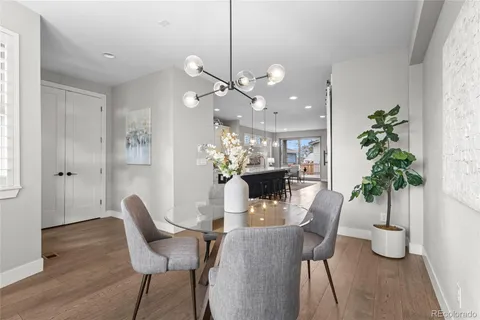 a dining room with furniture potted plants and wooden floor
