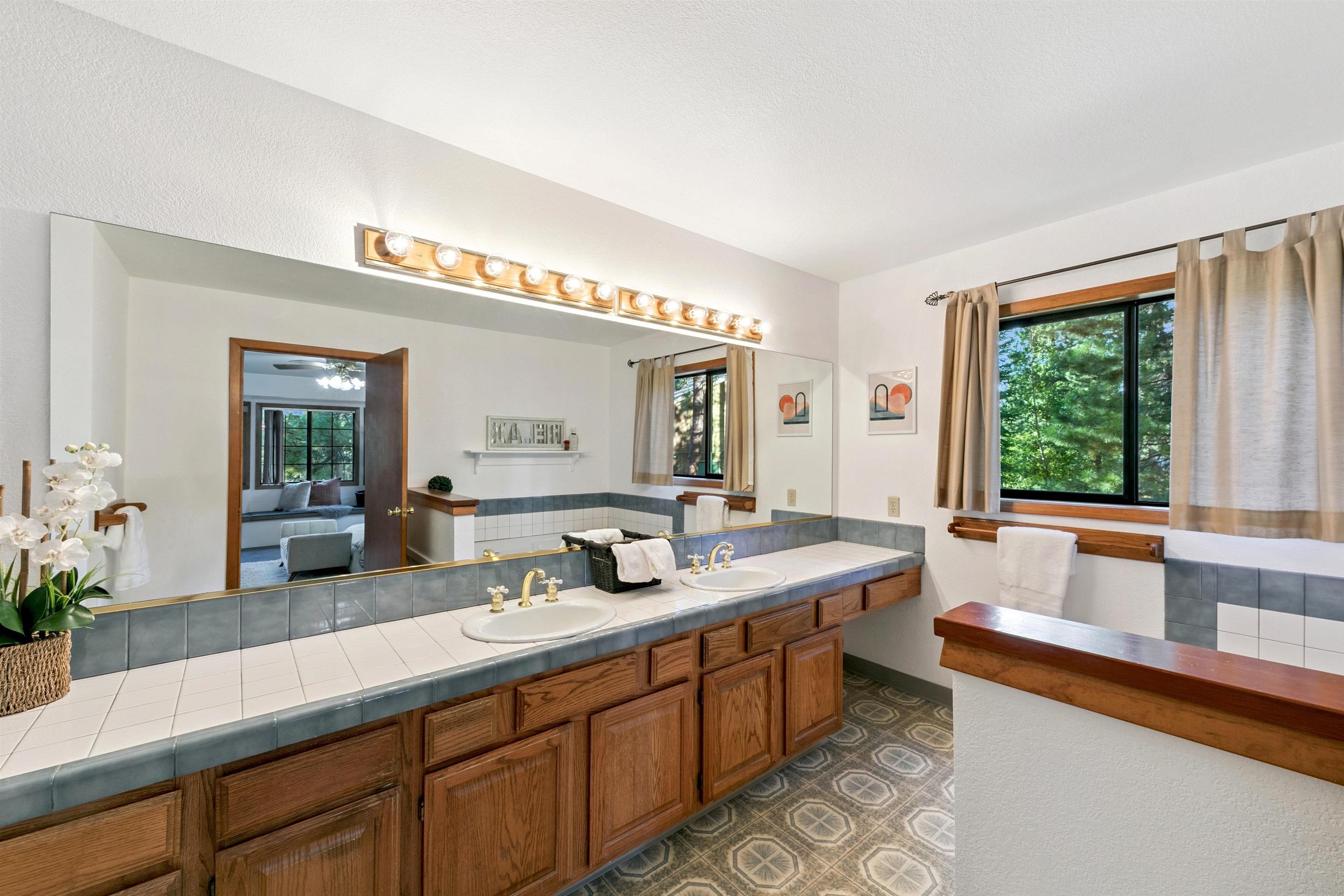 10625 Royal Crest Drive Truckee, CA 96161 - Photo 20 of 28 a spacious bathroom with a granite countertop sink and a large mirror