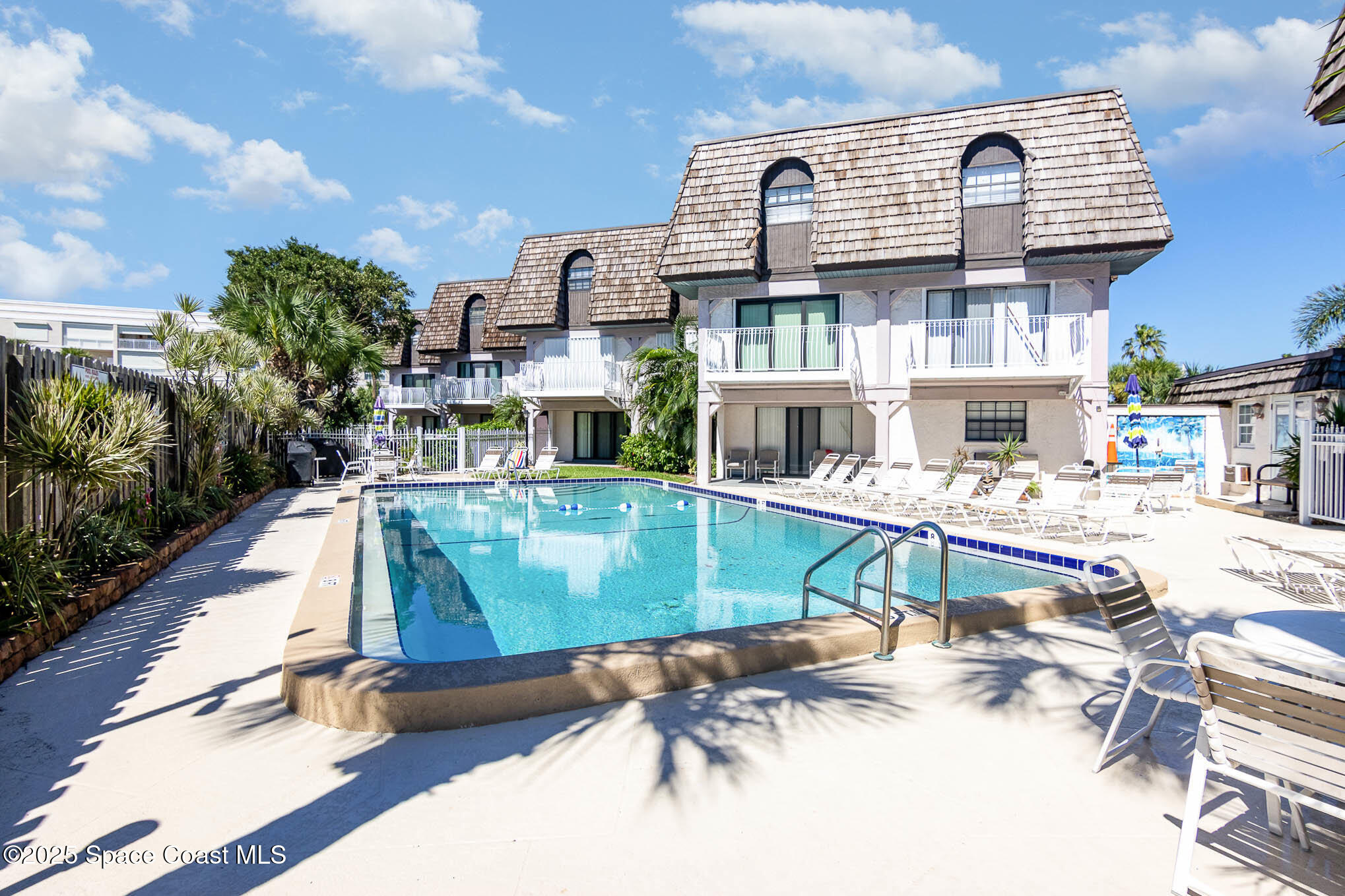 5350 Ocean Beach Boulevard, Unit 211 Cocoa Beach, FL 32931 - Photo 11 of 37 a swimming pool with outdoor seating and yard