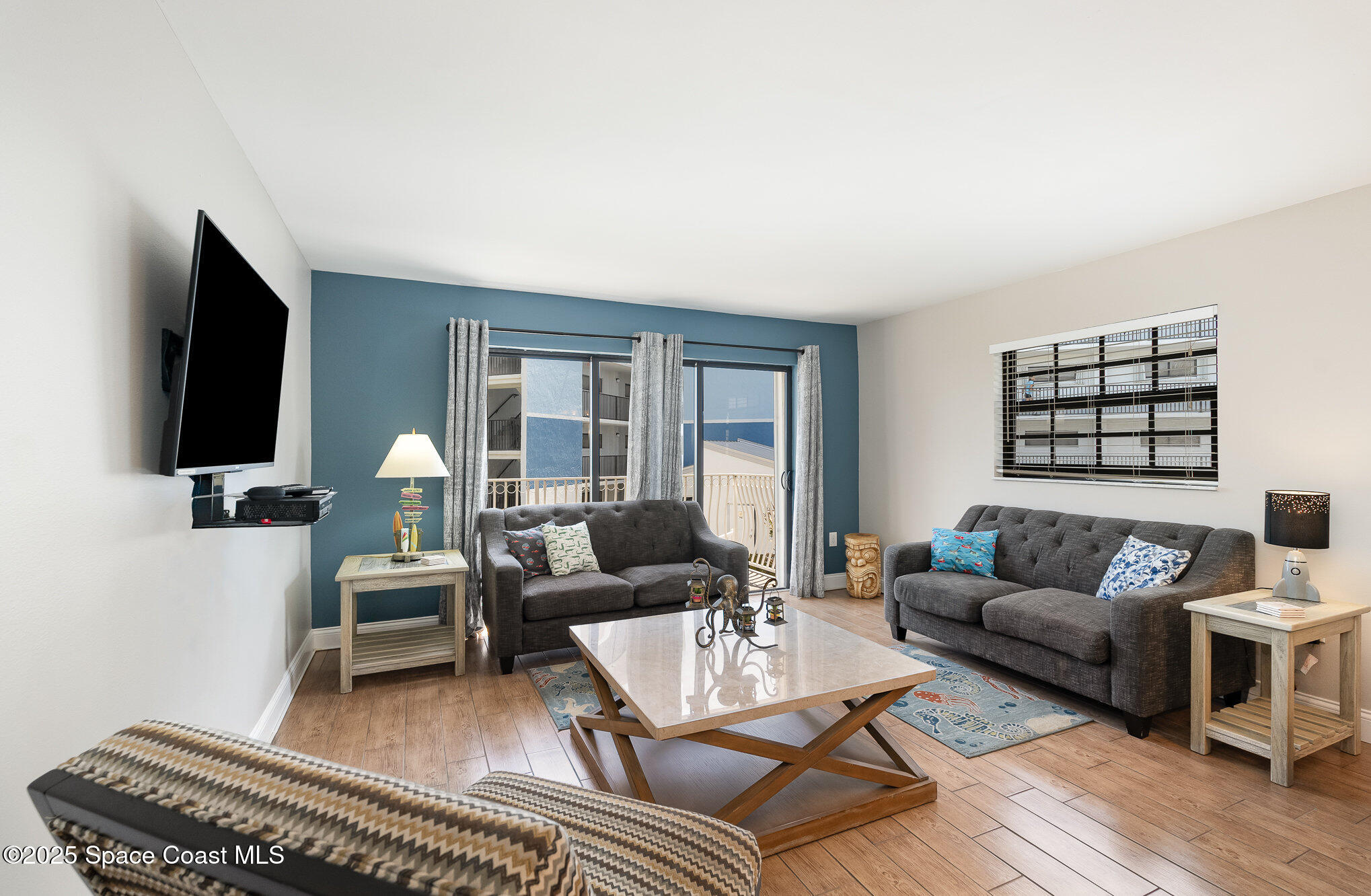 5350 Ocean Beach Boulevard, Unit 211 Cocoa Beach, FL 32931 - Photo 12 of 37 a living room with furniture and a flat screen tv