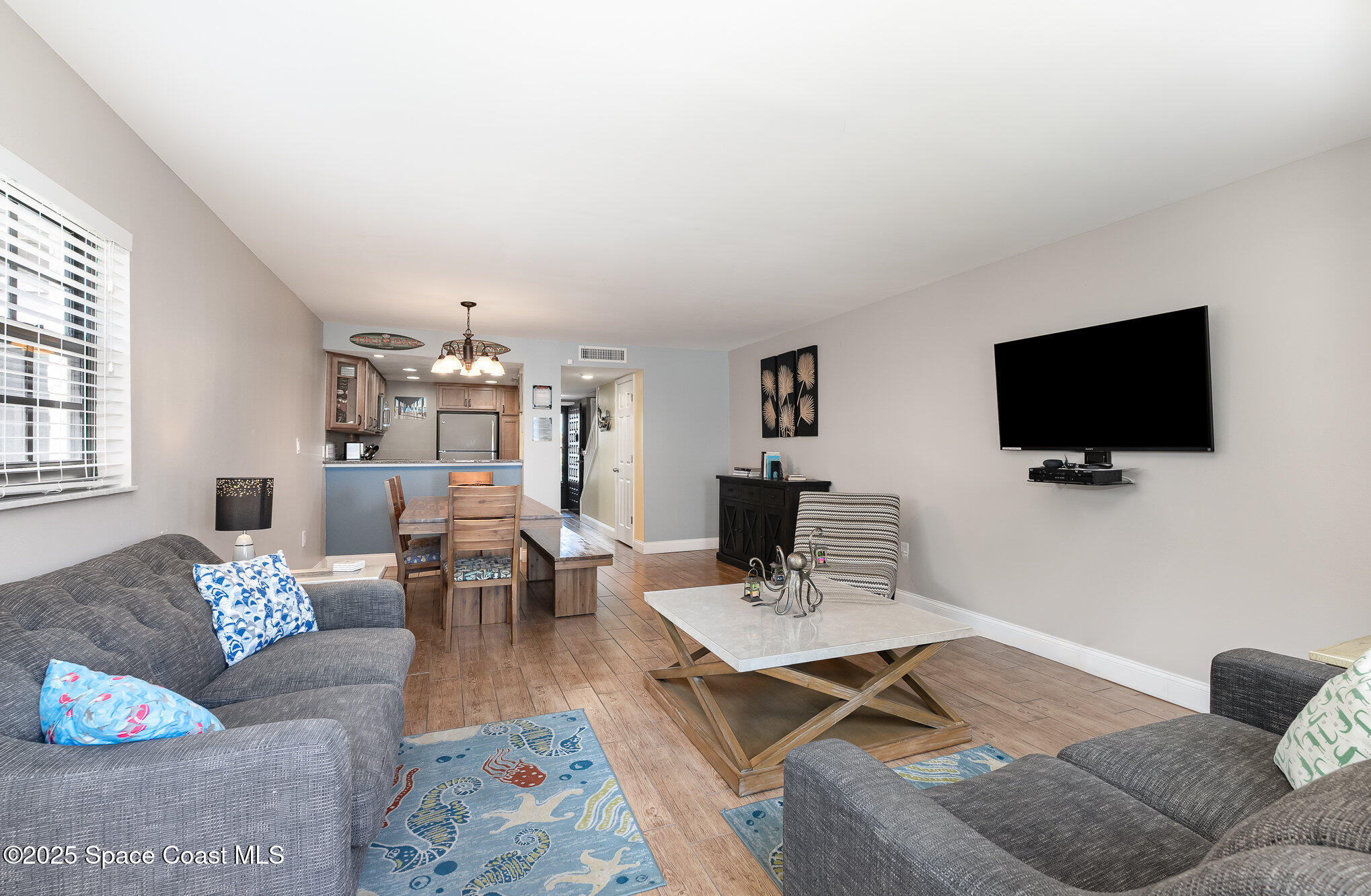 5350 Ocean Beach Boulevard, Unit 211 Cocoa Beach, FL 32931 - Photo 13 of 37 a living room with furniture and a flat screen tv
