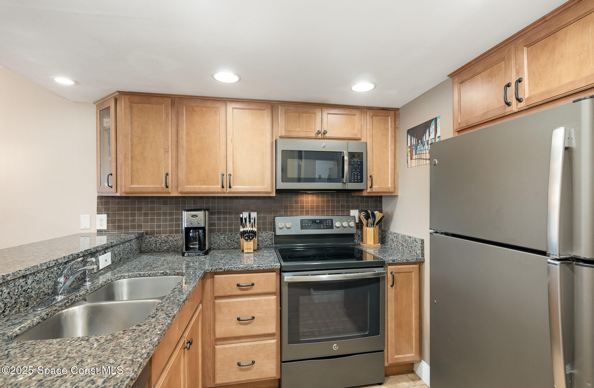 5350 Ocean Beach Boulevard, Unit 211 Cocoa Beach, FL 32931 - Photo 14 of 37 a kitchen with a refrigerator sink and microwave