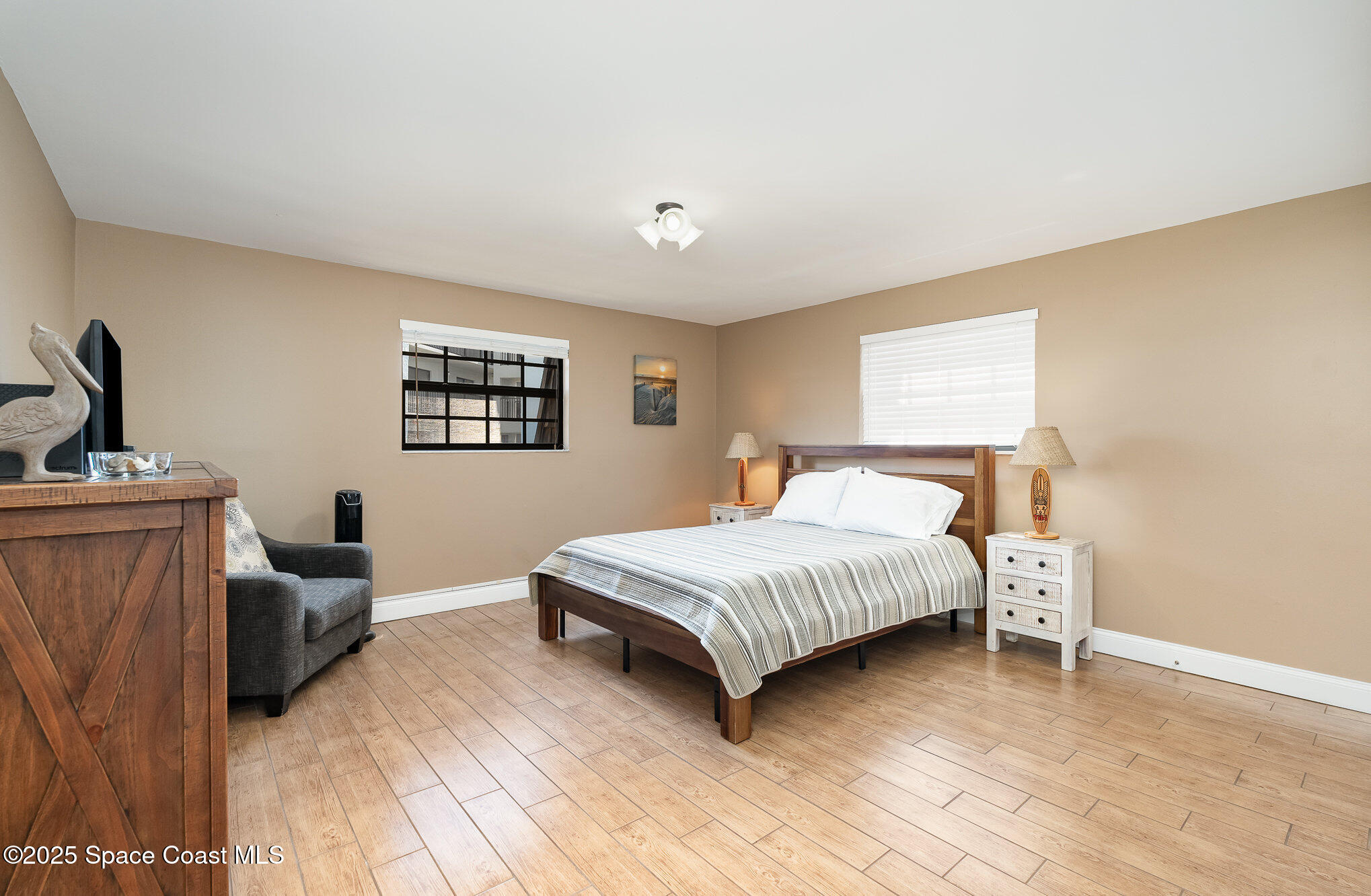 5350 Ocean Beach Boulevard, Unit 211 Cocoa Beach, FL 32931 - Photo 18 of 37 a spacious bedroom with a bed and a flat screen tv
