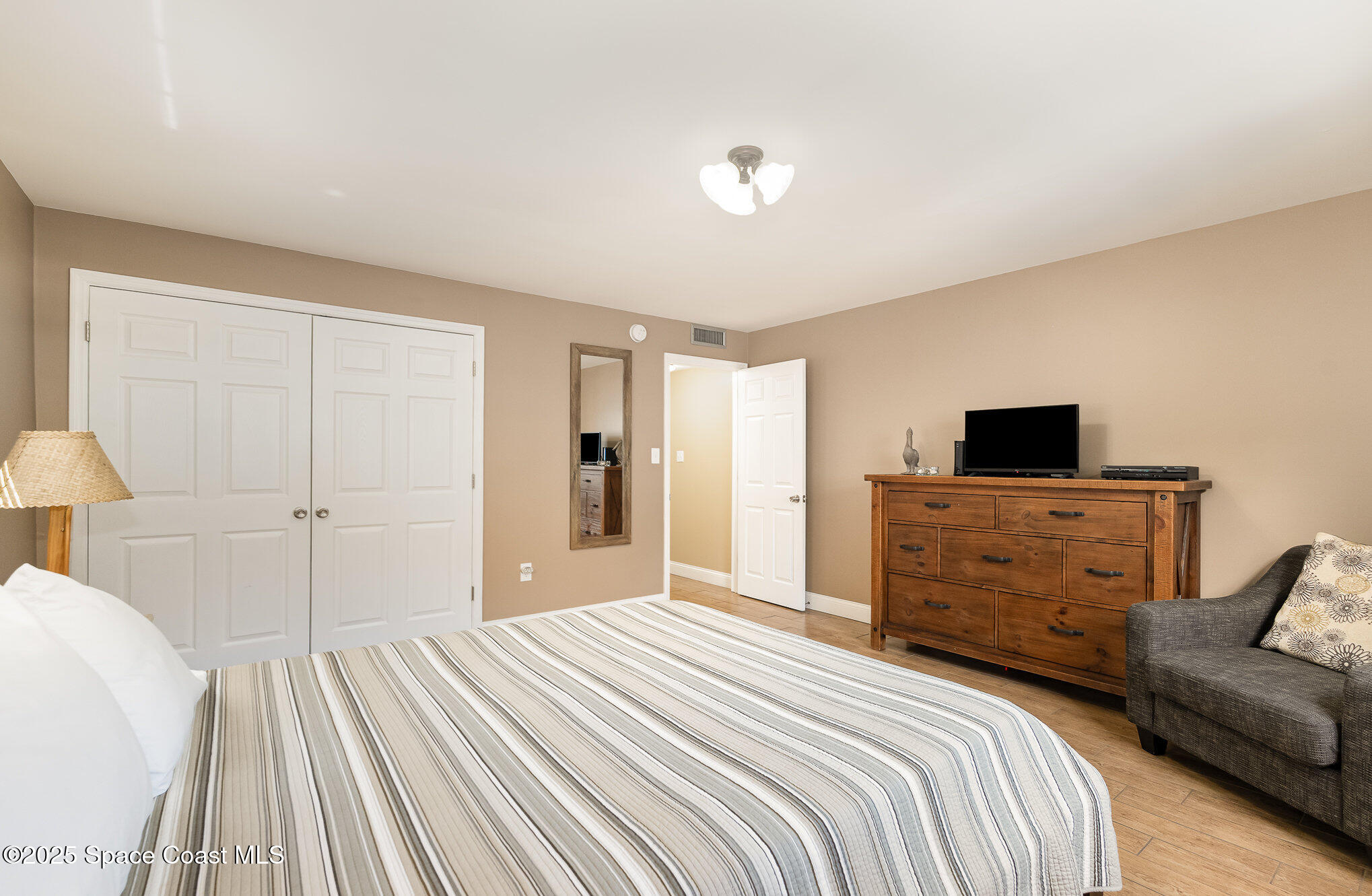 5350 Ocean Beach Boulevard, Unit 211 Cocoa Beach, FL 32931 - Photo 19 of 37 a bedroom with a bed and a flat screen tv