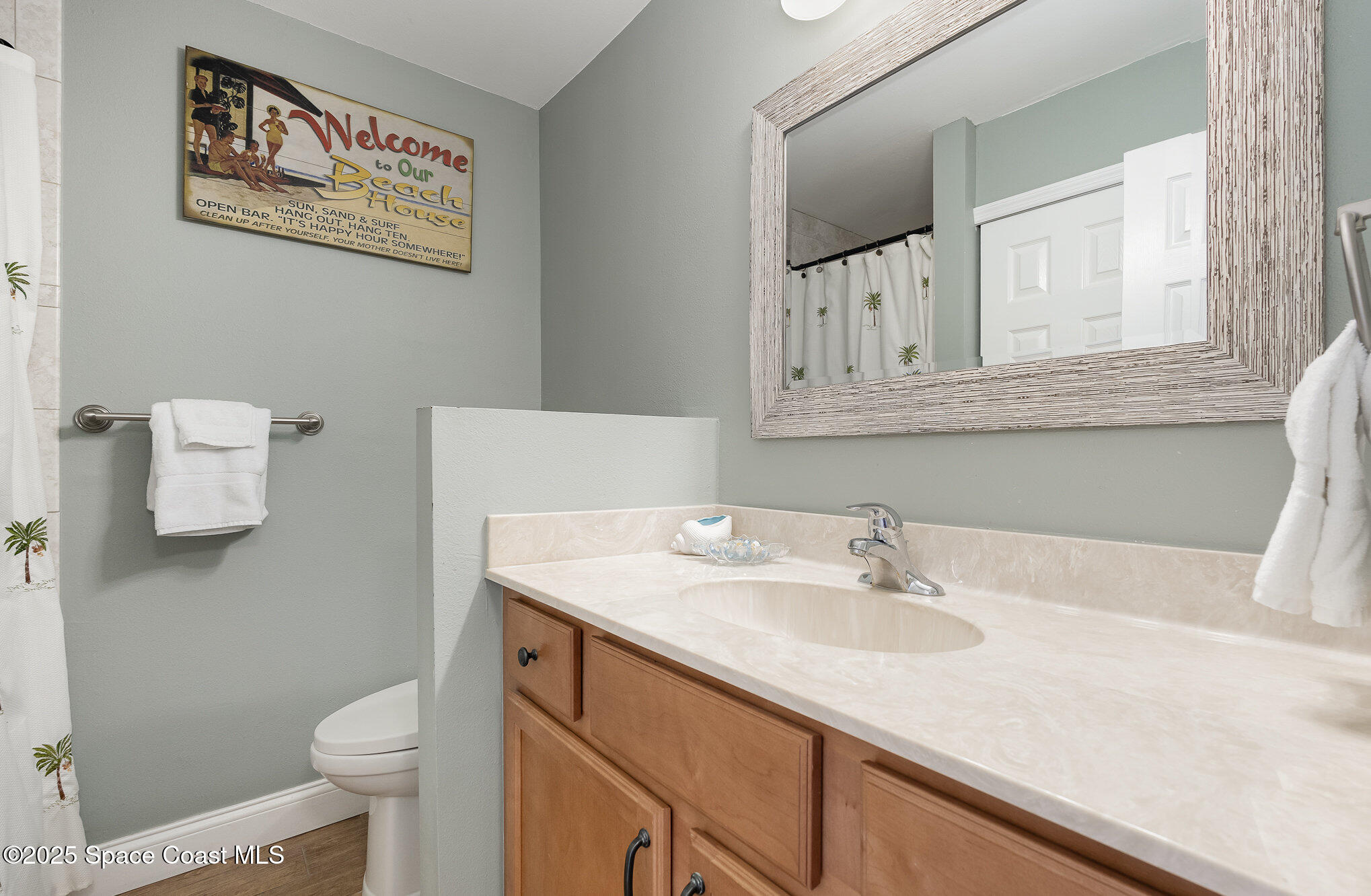 5350 Ocean Beach Boulevard, Unit 211 Cocoa Beach, FL 32931 - Photo 20 of 37 a bathroom with a sink toilet and a mirror