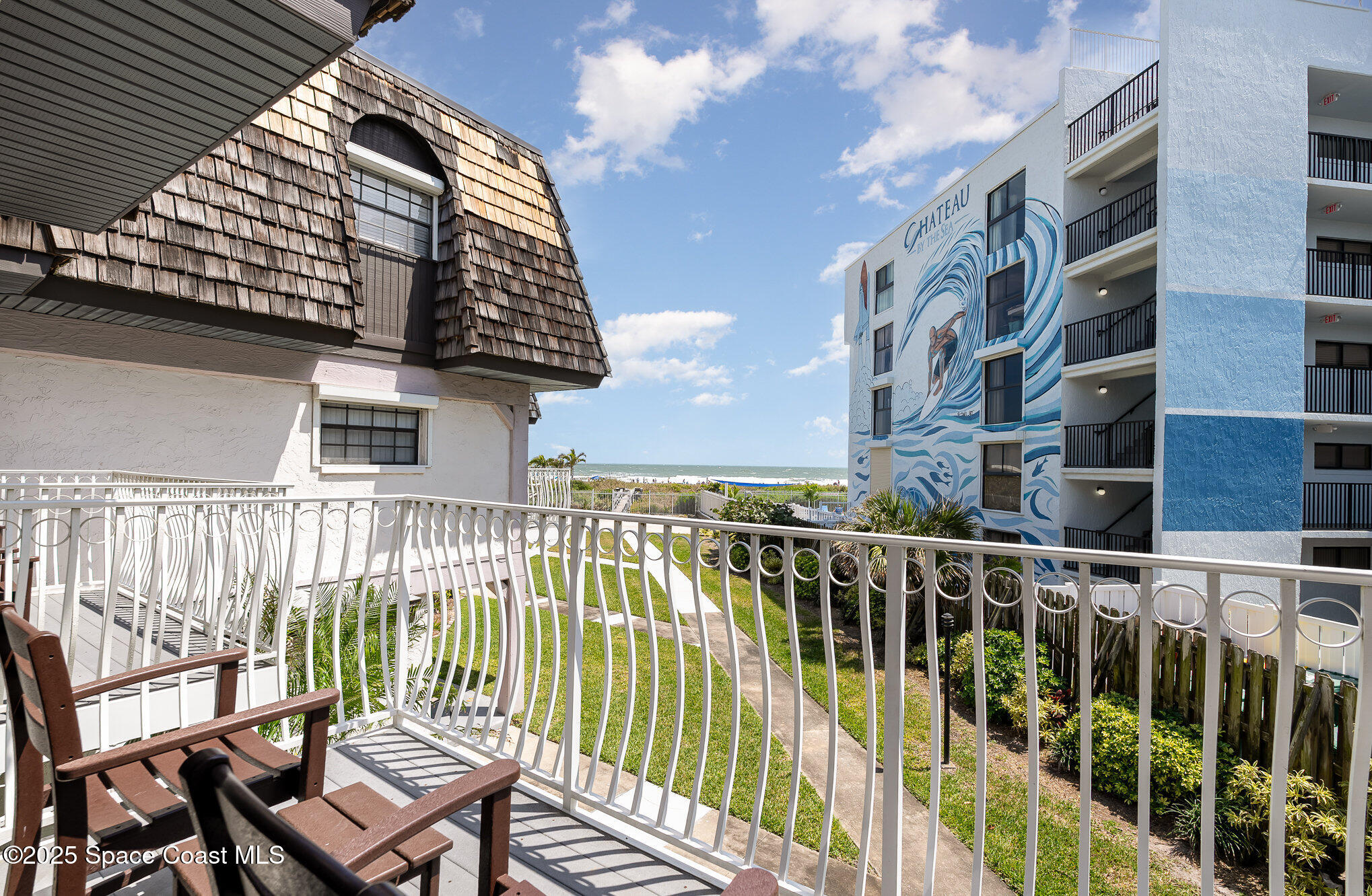 5350 Ocean Beach Boulevard, Unit 211 Cocoa Beach, FL 32931 - Photo 4 of 37 a view of a balcony with a chair and iron fence