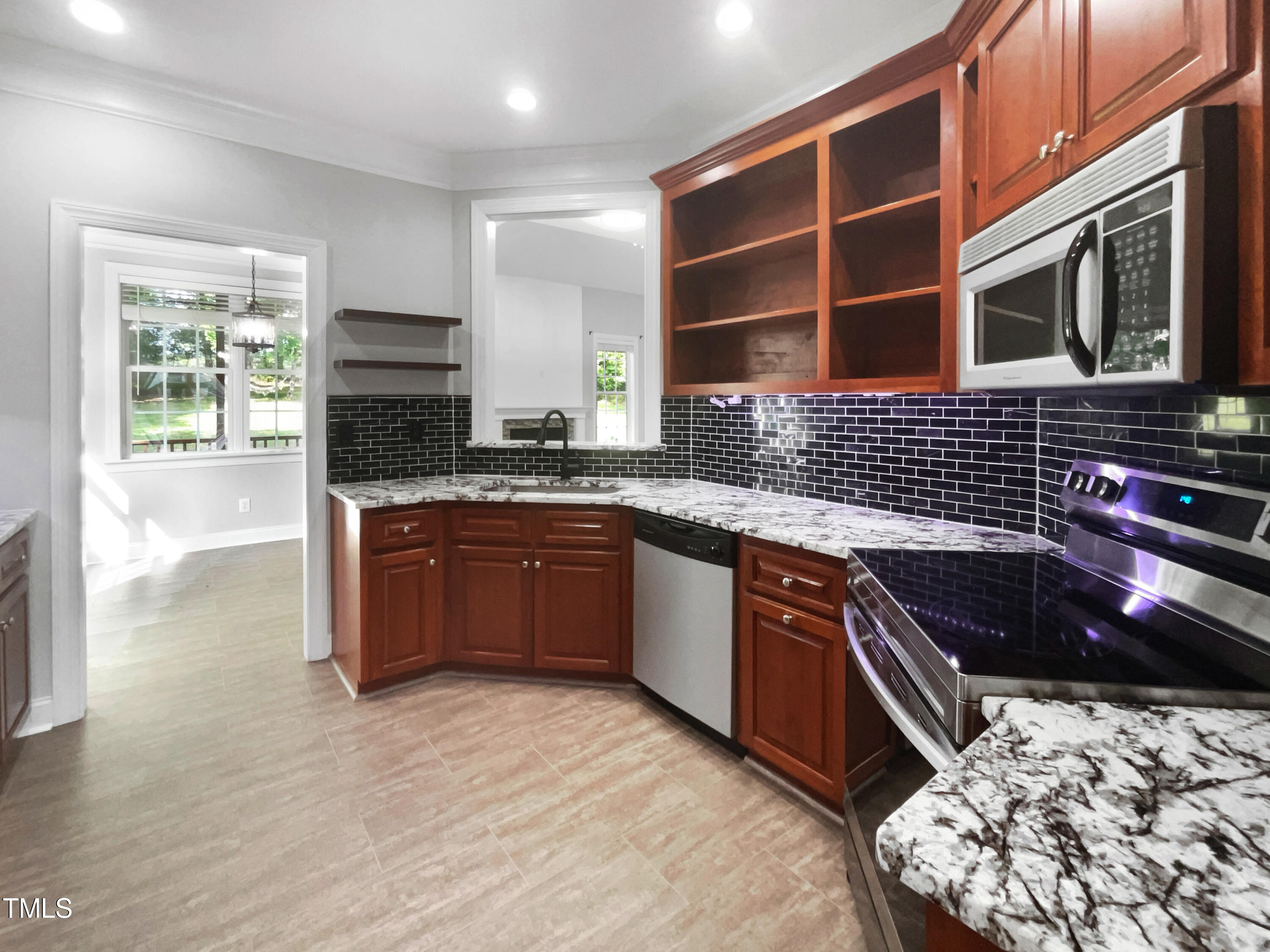 90 Carrousel Court Angier, NC 27501 - Photo 30 of 31 a kitchen with stainless steel appliances granite countertop a stove sink and cabinets