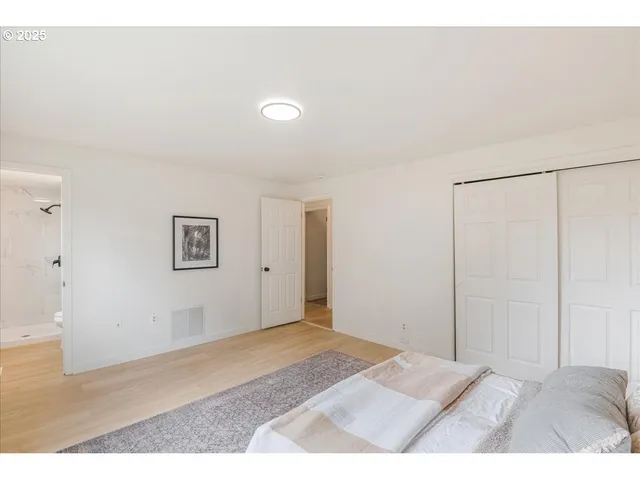 a bedroom with a bed and a painting on the wall