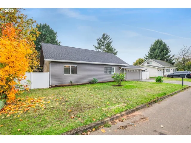 a view of a yard in front of a house with large trees