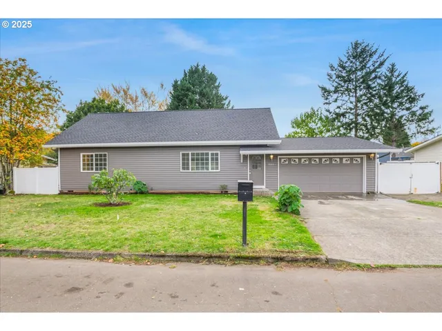 a front view of a house with a garden and yard