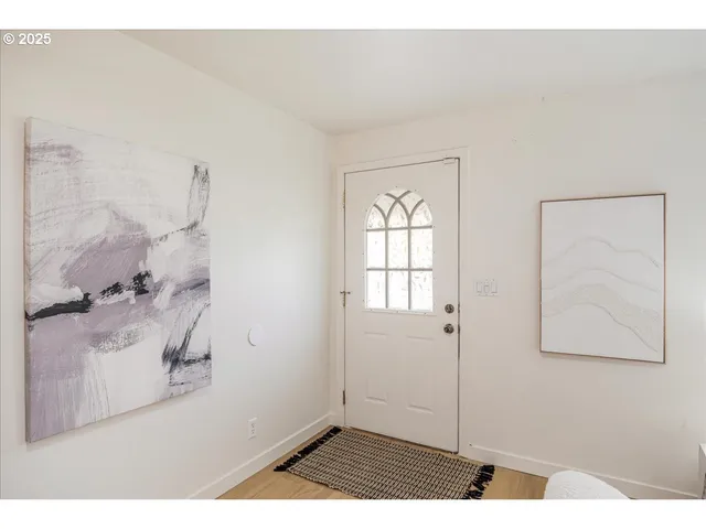 a view of a bedroom with wooden floor and windows
