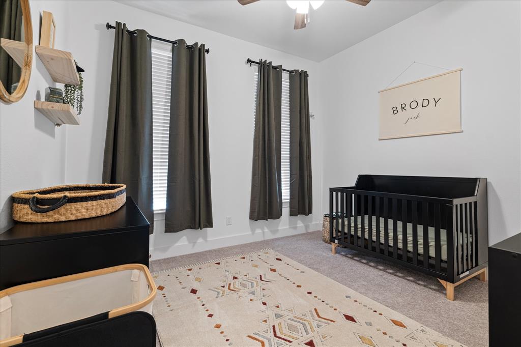 1332 Thompson Road Argyle, TX 76226 - Photo 21 of 36 Bedroom featuring a crib, light colored carpet, and ceiling fan