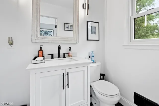 a bathroom with a sink toilet and a window