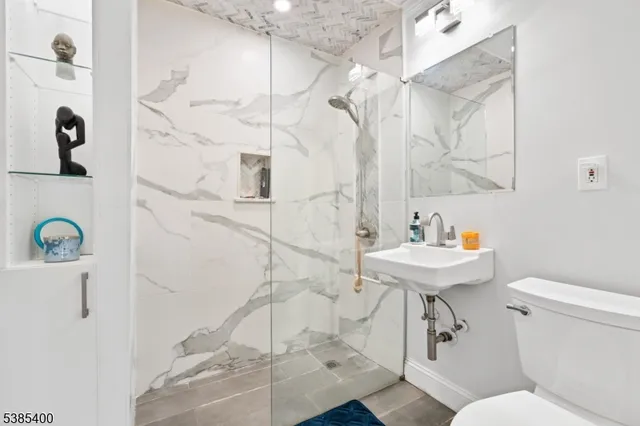 a bathroom with a sink a toilet and shower