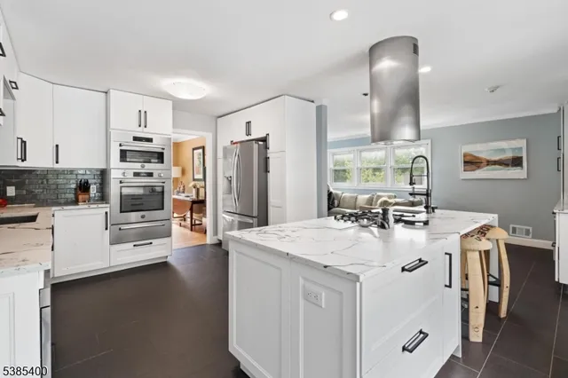 a kitchen with stainless steel appliances a stove refrigerator sink and dishwasher with wooden floor