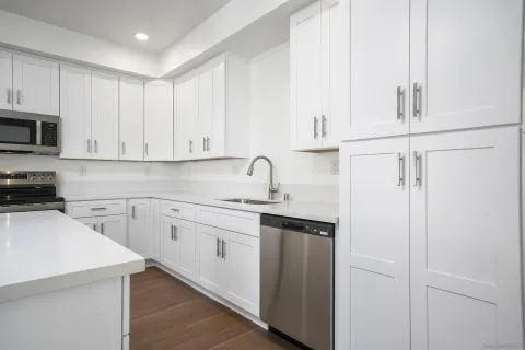a kitchen with stainless steel appliances granite countertop a stove a sink and a microwave