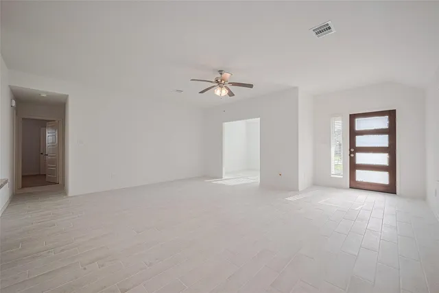 an empty room with closet and a ceiling fan