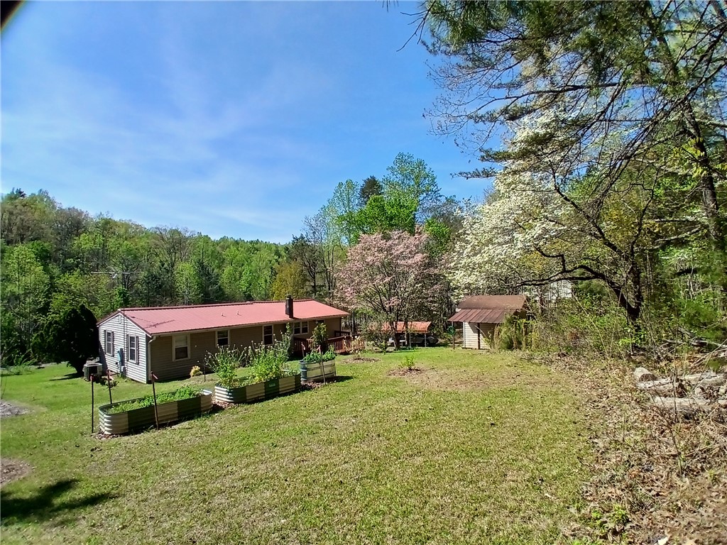 319 Cove Creek Road Pickens, SC 29671 - Photo 2 of 20 This charming home features a verdant private yard with lush landscaping and garden beds.