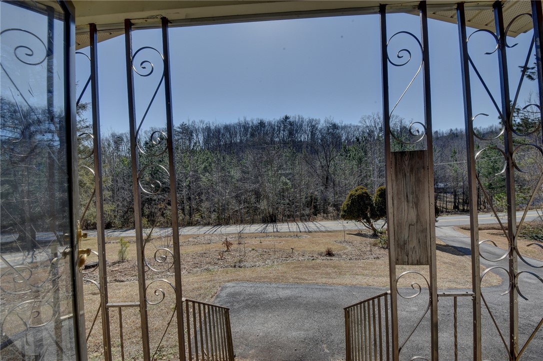 319 Cove Creek Road Pickens, SC 29671 - Photo 9 of 22 This porch entry offers a view of mature trees and a private driveway.