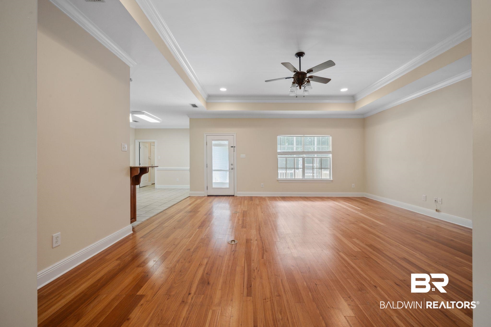 2041 Ridgeline Drive Mobile, AL 36695 - Photo 26 of 43 Unfurnished living room featuring light tile patterned flooring, ceiling fan, a tray ceiling, and ornamental molding
