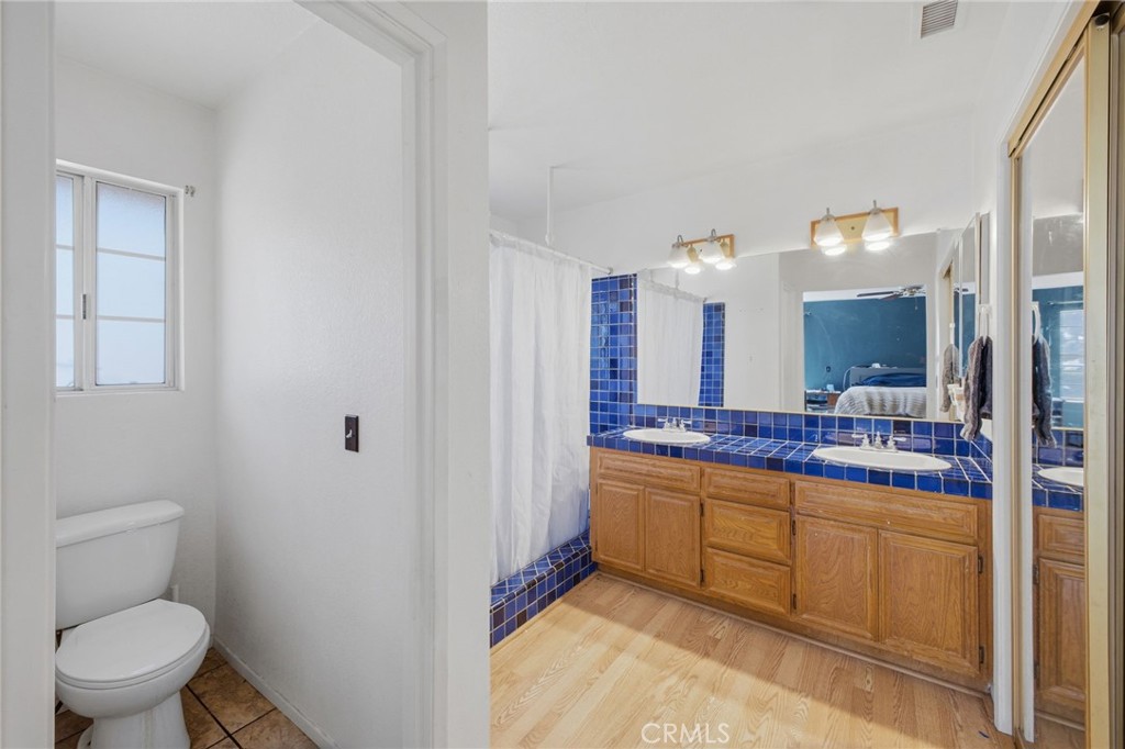 19992 Covell Street Riverside, CA 92508 - Photo 32 of 57 a spacious bathroom with a toilet sink and mirror