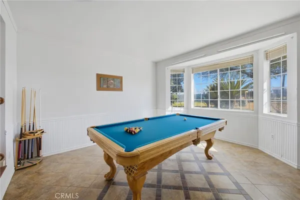 a room with pool table and windows
