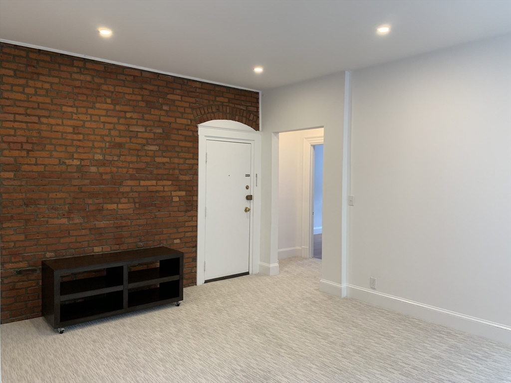 1064 Beacon Street, Unit 9 Brookline, MA 02446 - Photo 15 of 19 a view of an empty room with cabinet and a hallway