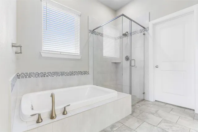 a bathroom with a tub shower and a sink