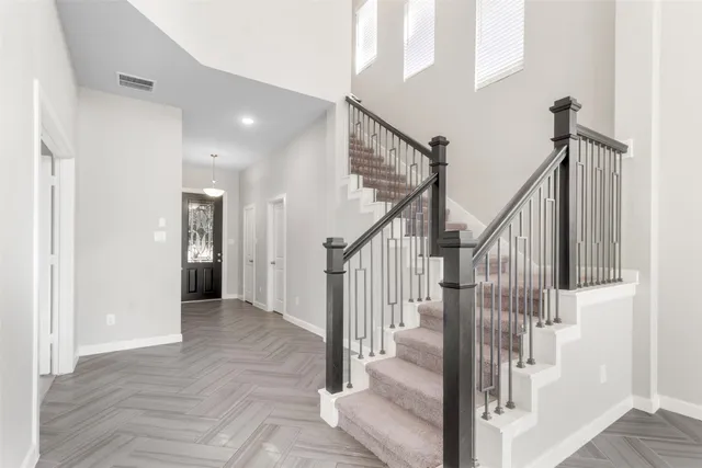 a view of a hallway with wooden floor and staircase