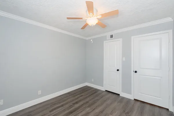 a view of an empty room with wooden floor