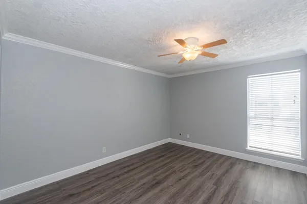 a view of a room with wooden floor and a ceiling fan