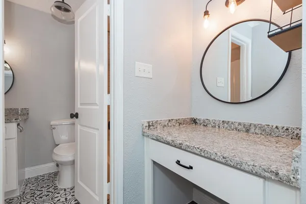 a bathroom with a granite countertop sink and a mirror