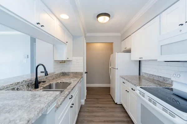 a kitchen with stainless steel appliances granite countertop a sink a stove and refrigerator