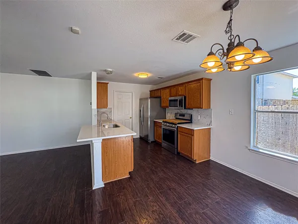 a kitchen with stainless steel appliances granite countertop a stove and wooden floor