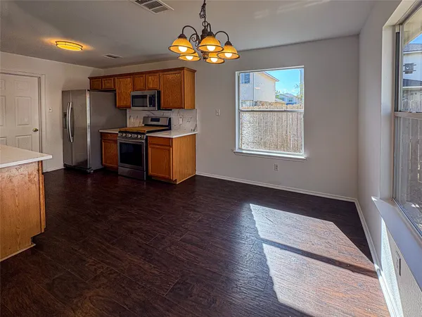 a kitchen with granite countertop stainless steel appliances and wooden floor
