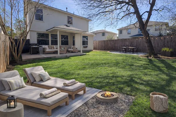 a backyard of a house with fountain table and chairs