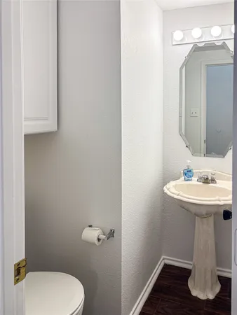 a bathroom with a sink a toilet and mirror