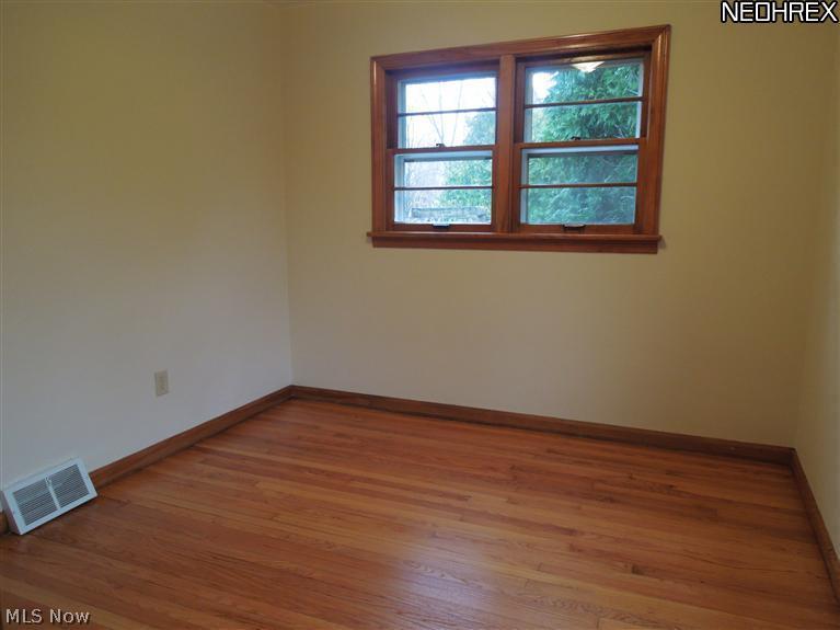 Refinished hardwood floor and neutral decor in 1 bedroom.