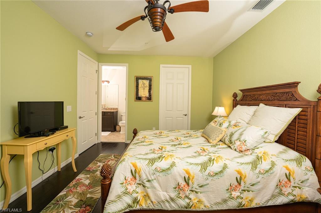 8986 Cambria Circle, Unit 22 Naples, FL 34113 - Photo 14 of 20 Bedroom featuring ensuite bath, ceiling fan, and dark hardwood / wood-style flooring