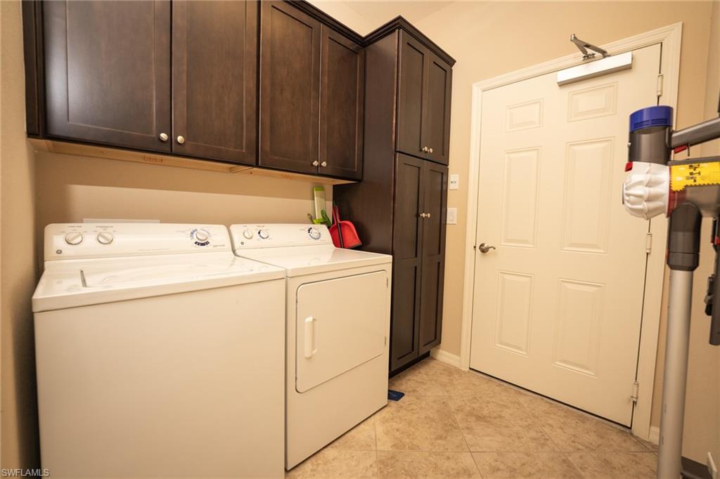 8986 Cambria Circle, Unit 22 Naples, FL 34113 - Photo 18 of 20 Laundry area featuring washer and clothes dryer, cabinets, and light tile patterned floors