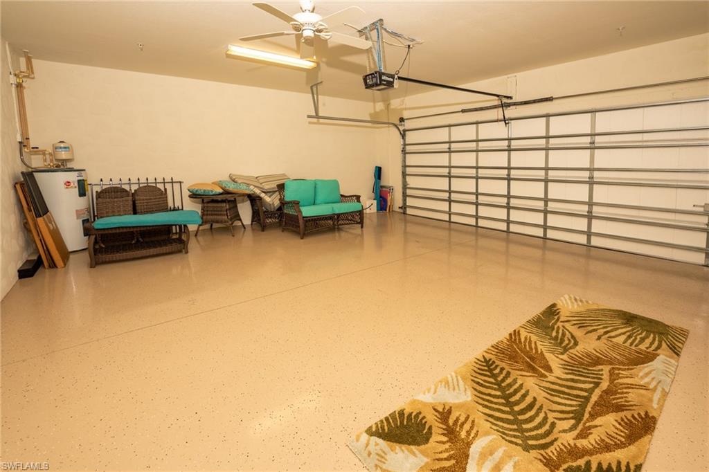 8986 Cambria Circle, Unit 22 Naples, FL 34113 - Photo 20 of 20 Garage featuring a garage door opener, ceiling fan, and water heater