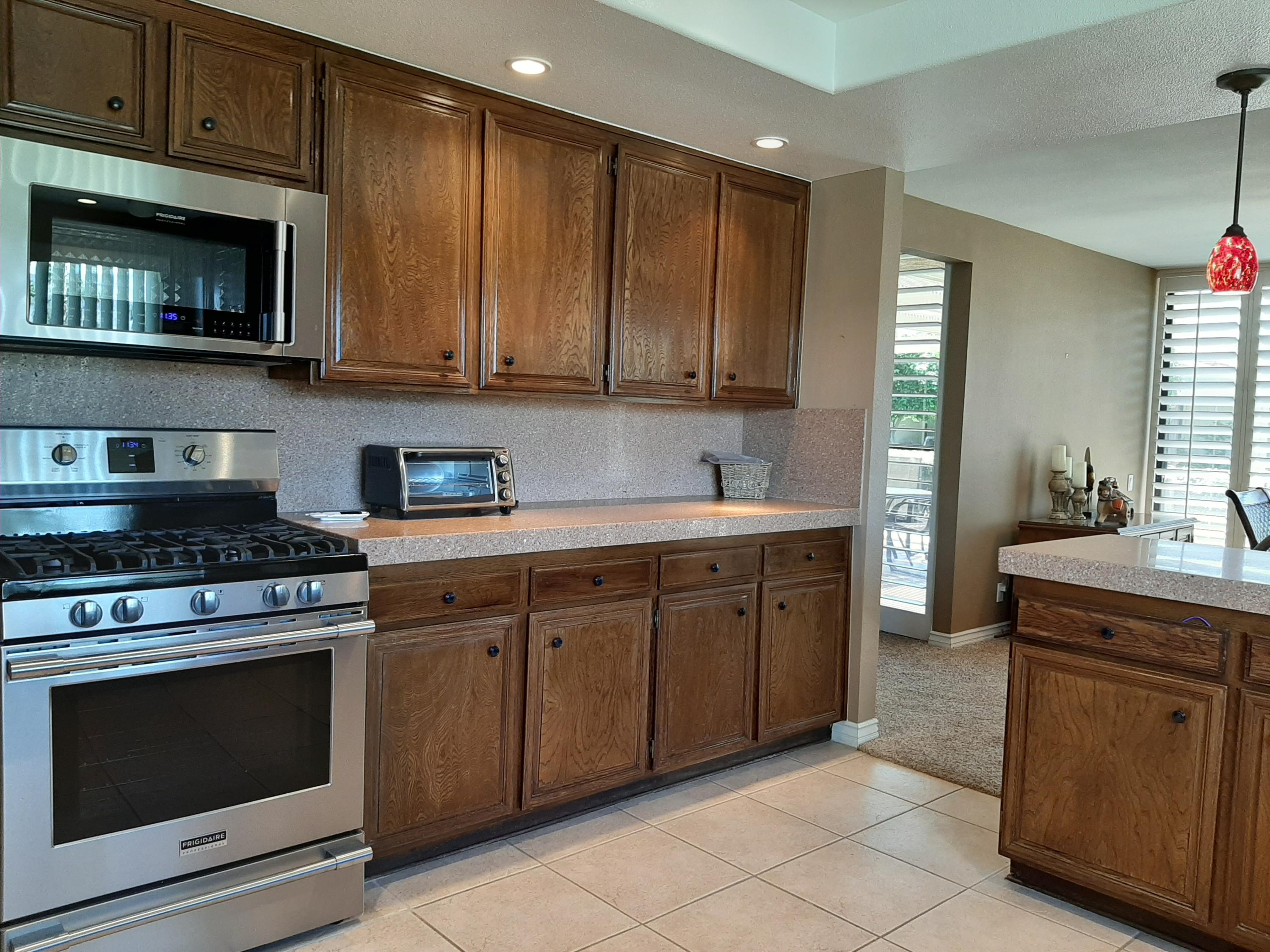 72385 Beverly Way Rancho Mirage, CA 92270 - Photo 16 of 24 a kitchen with stainless steel appliances granite countertop a stove microwave and cabinets