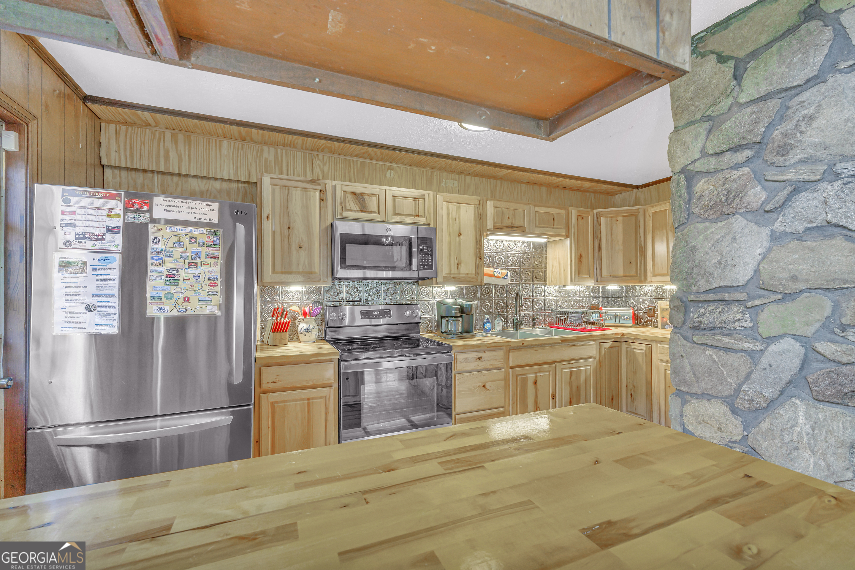 243 Ridge Road Helen, GA 30545 - Photo 28 of 82 a kitchen with stainless steel appliances kitchen island granite countertop a refrigerator and stove top oven