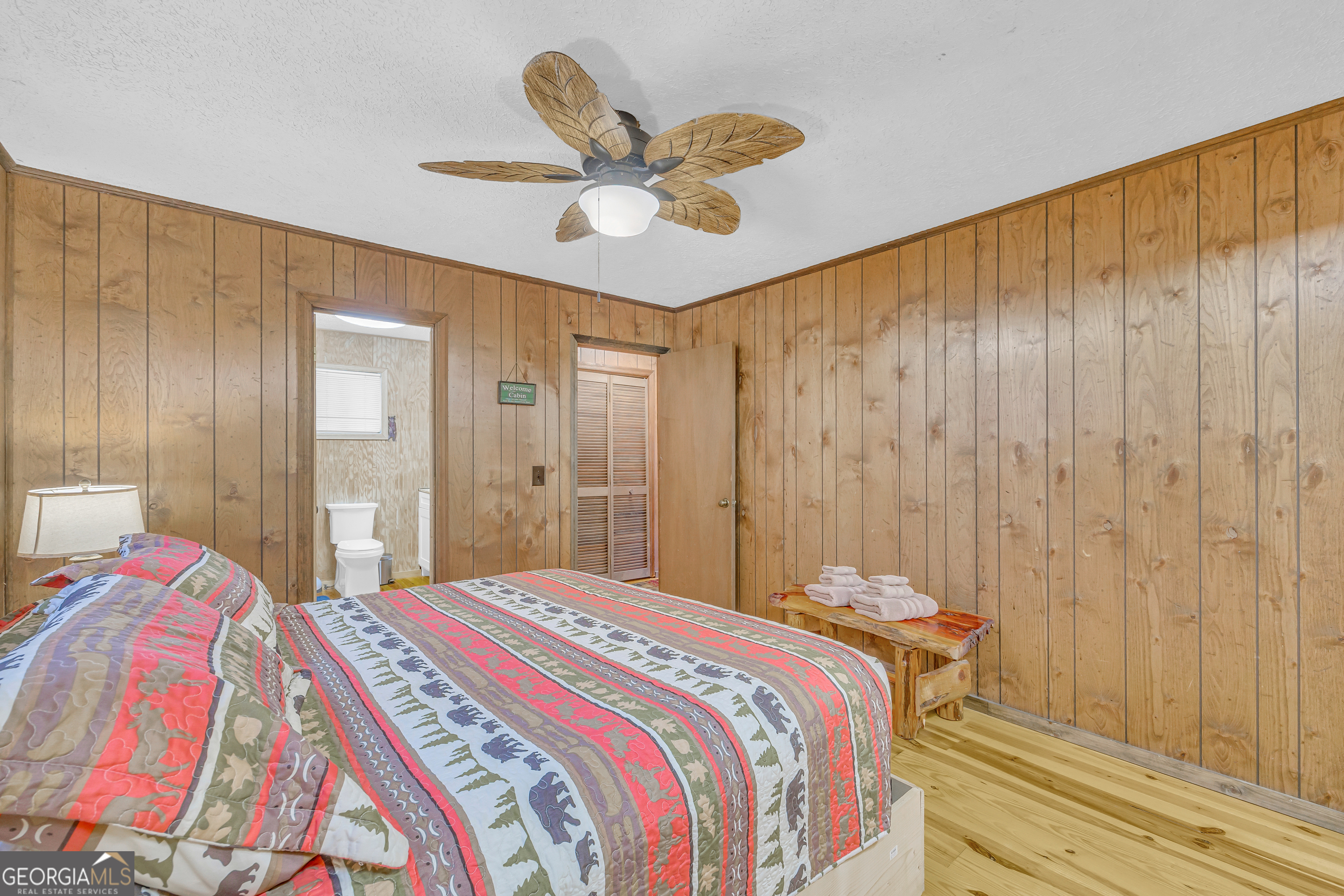 243 Ridge Road Helen, GA 30545 - Photo 32 of 82 a bedroom with a bed and a chandelier