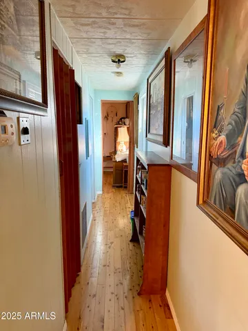 a view of a hallway with wooden floor and furniture