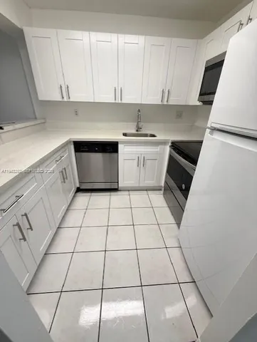 a kitchen with a white cabinets and white appliances