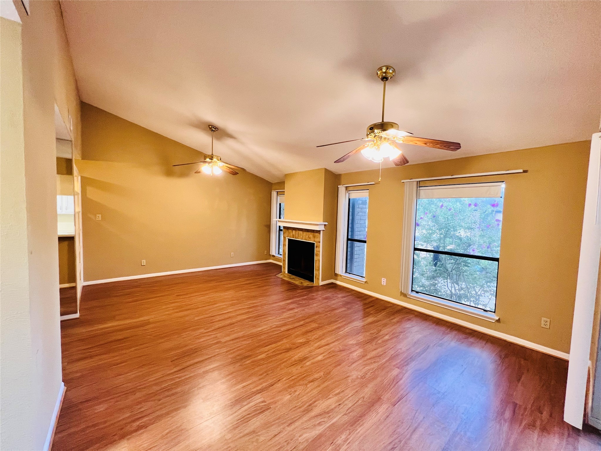 12755 Mill Ridge Drive, Unit 311 Cypress, TX 77429 - Photo 8 of 17 an empty room with wooden floor fireplace and windows